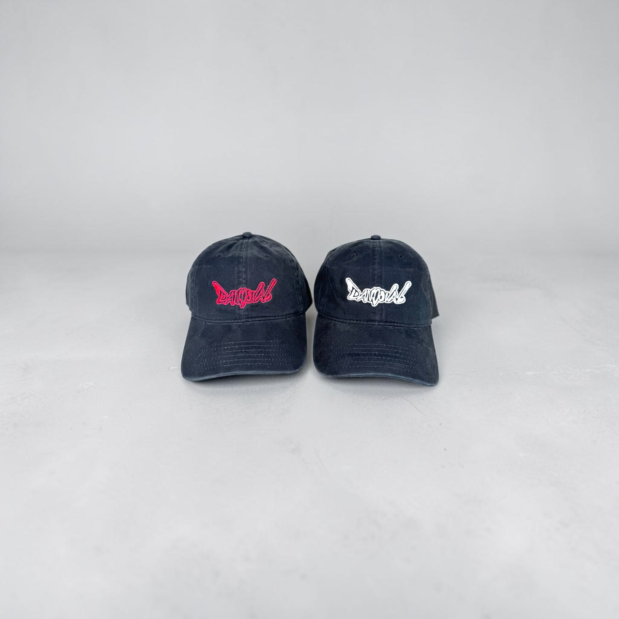 Two navy blue caps with embroidered designs on a white background