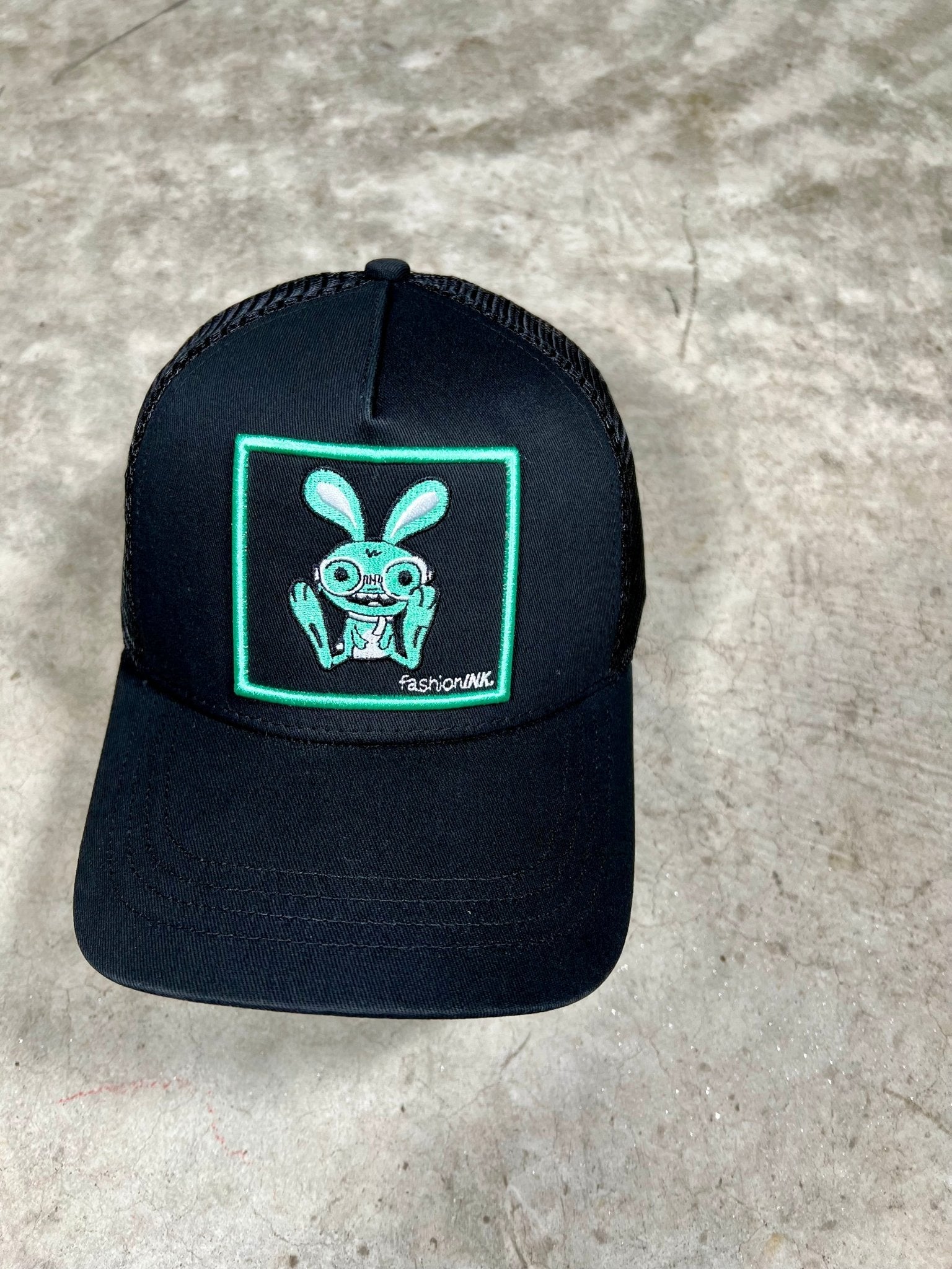 "Close-up of Bunny Trucker Hat with embroidered bunny design by fashionINK, featuring a breathable mesh back and adjustable snapback closure."