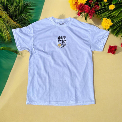 White t-shirt with 'Make Peace Love' text on a yellow surface with flowers and leaves.