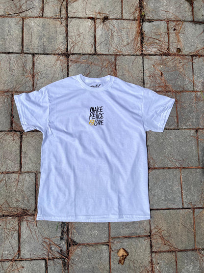 White t-shirt with 'Make Peace Love' text on a textured stone surface
