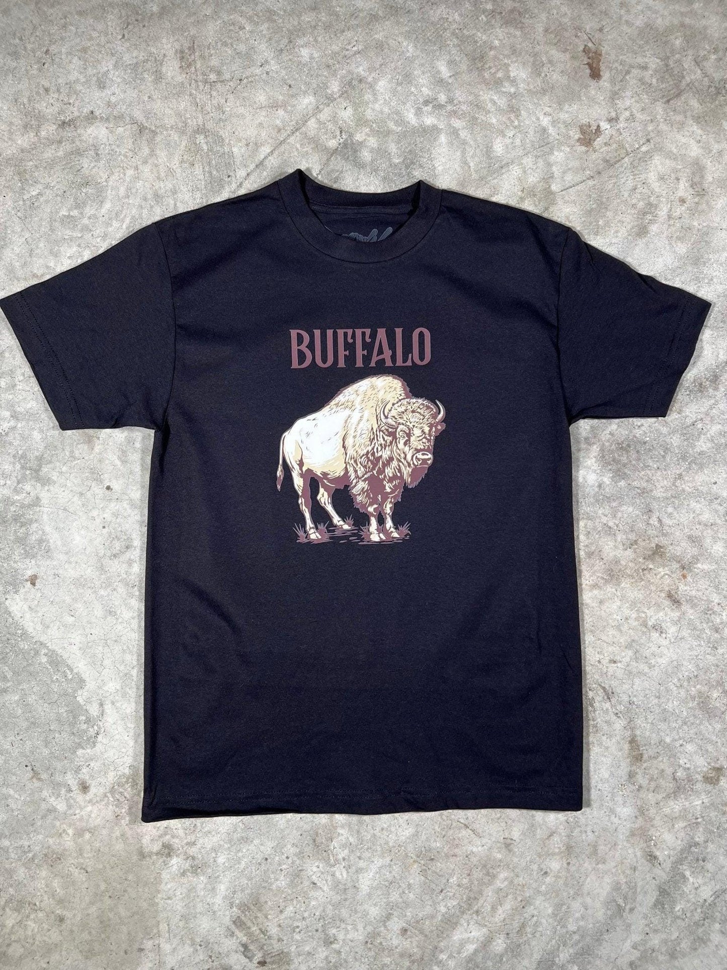Black t-shirt with a graphic of a buffalo and the word 'BUFFALO' on a concrete floor.