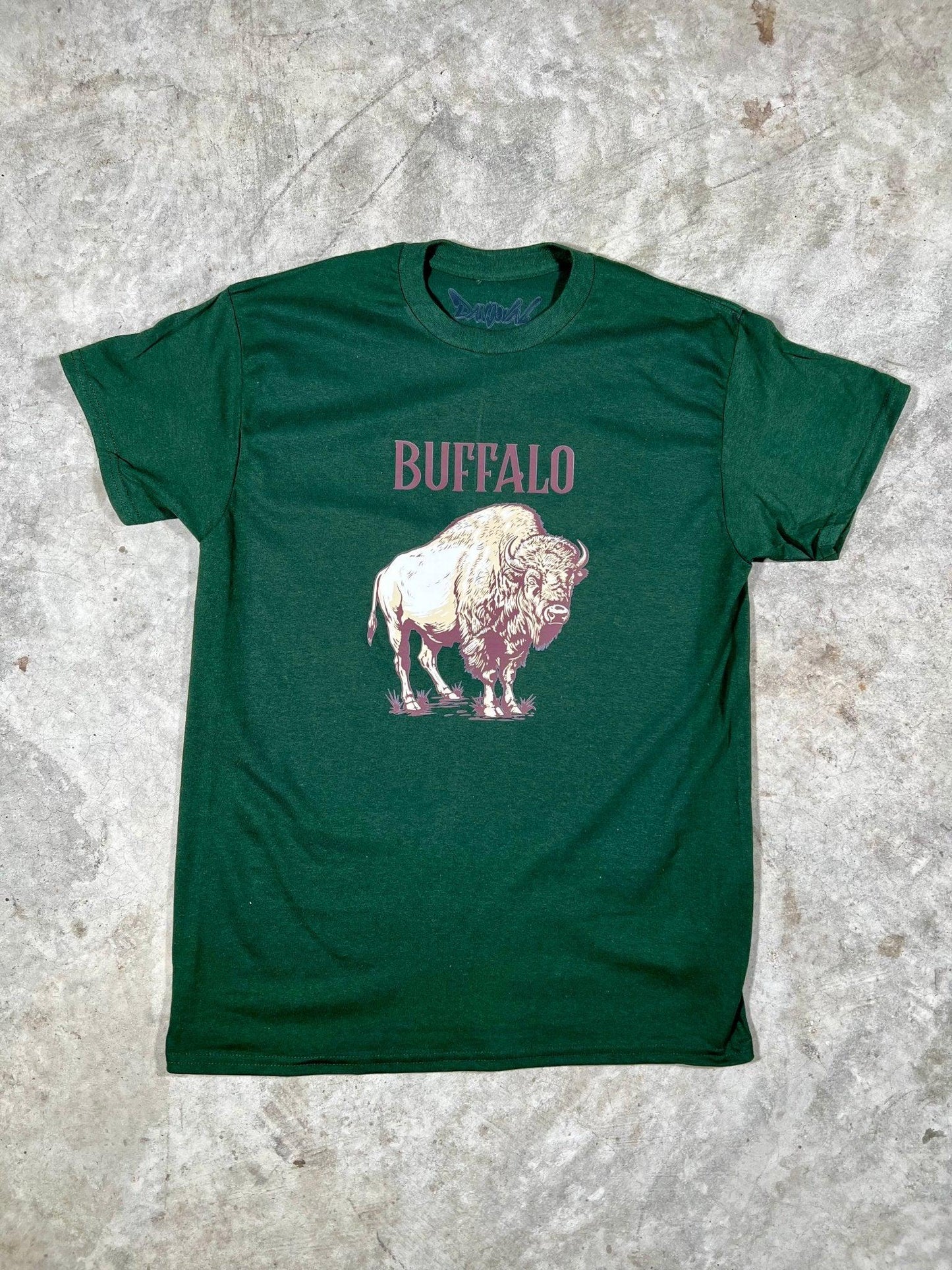 Green t-shirt with a pink buffalo graphic and 'BUFFALO' text on a textured gray background