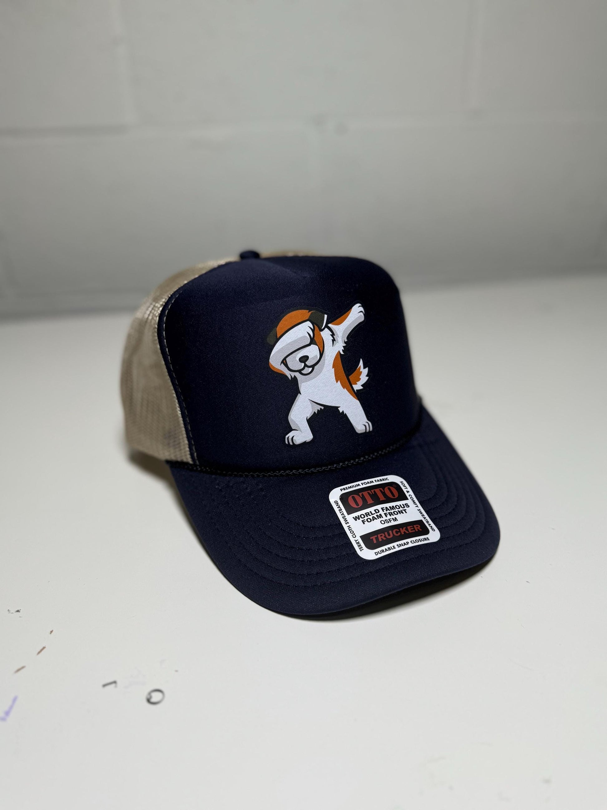 Navy blue cap with cartoon character and beige visor on a white surface