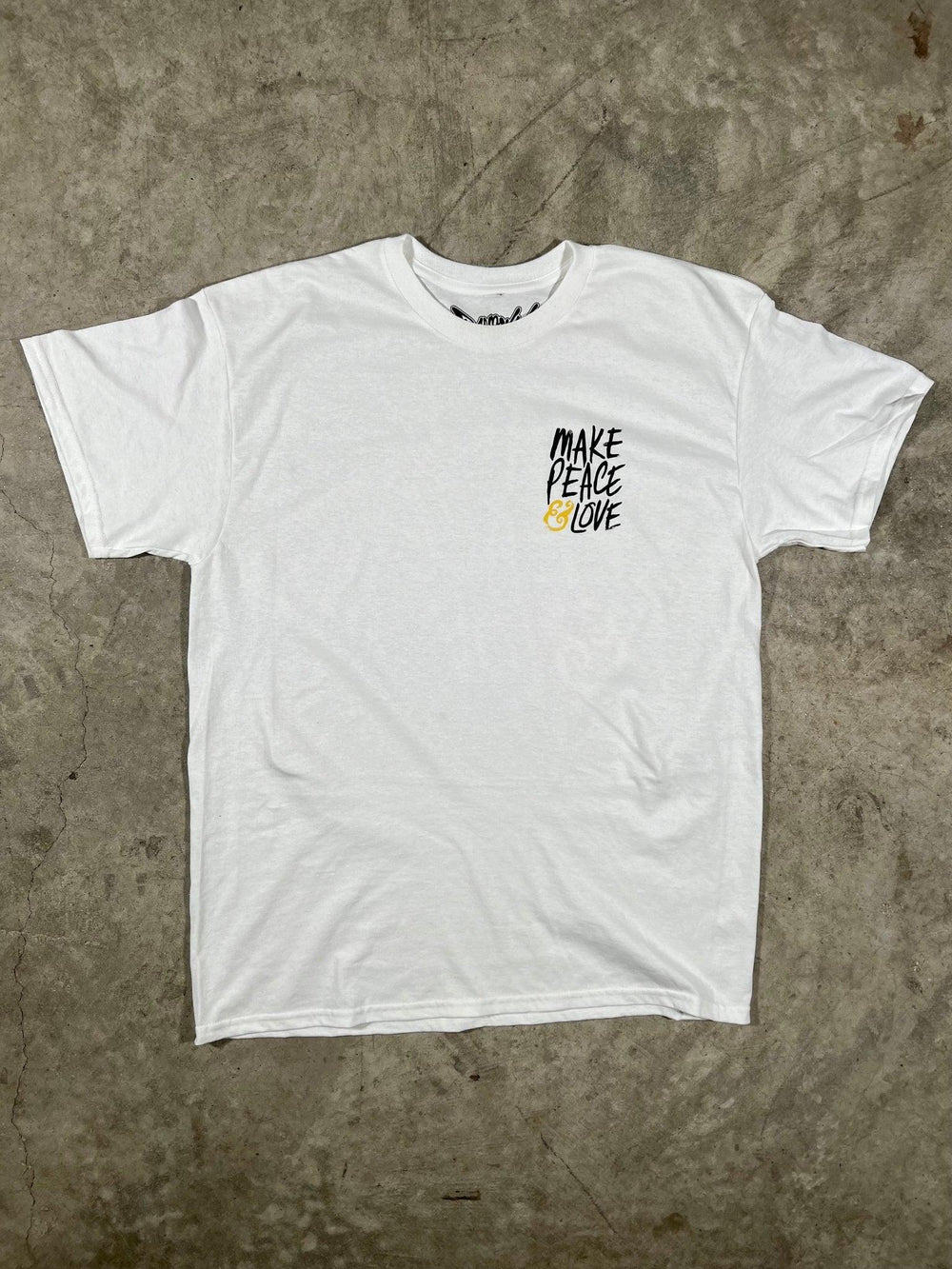 White t-shirt with 'Make Peace Love' text on a textured surface