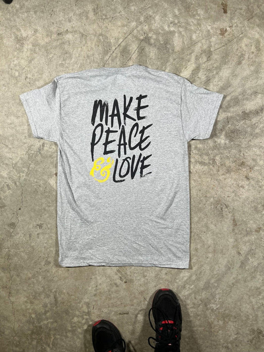 Gray t-shirt with 'MAKE PEACE LOVE' text on a concrete floor.