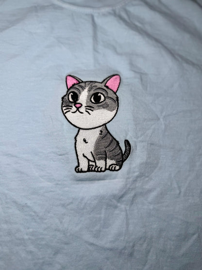 Embroidered cat patch on a light gray fabric background