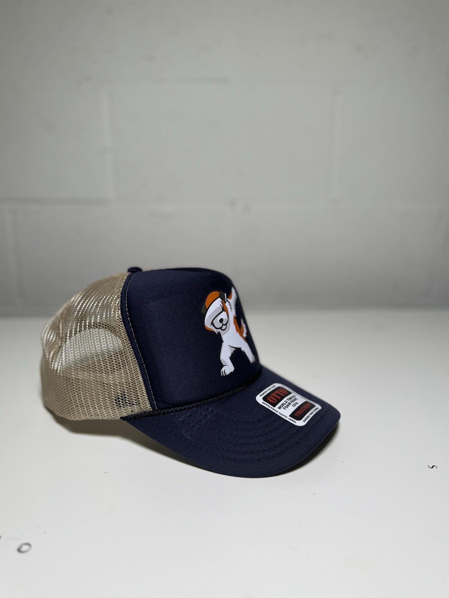Navy blue trucker hat with a dog graphic on a white background