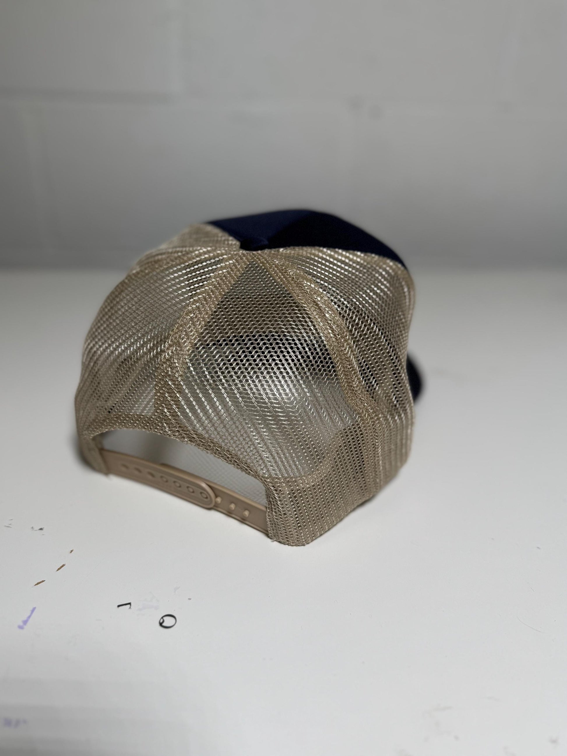 Beige mesh cap on a white surface with a blurred background