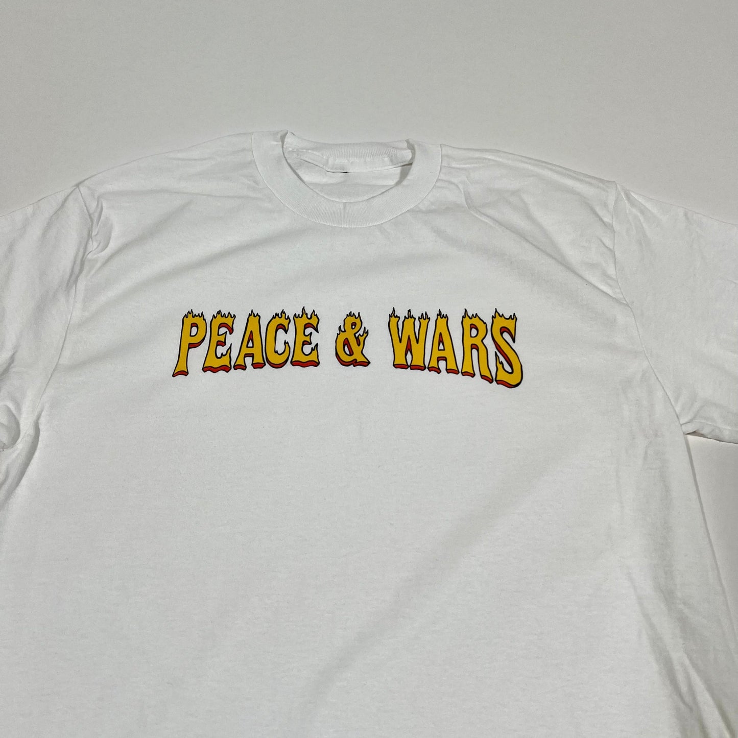 "Peace & Wars OG Logo T-Shirt featuring iconic design, made from 100% combed ringspun cotton, unisex fit, perfect for sci-fi and alien invasion fans."