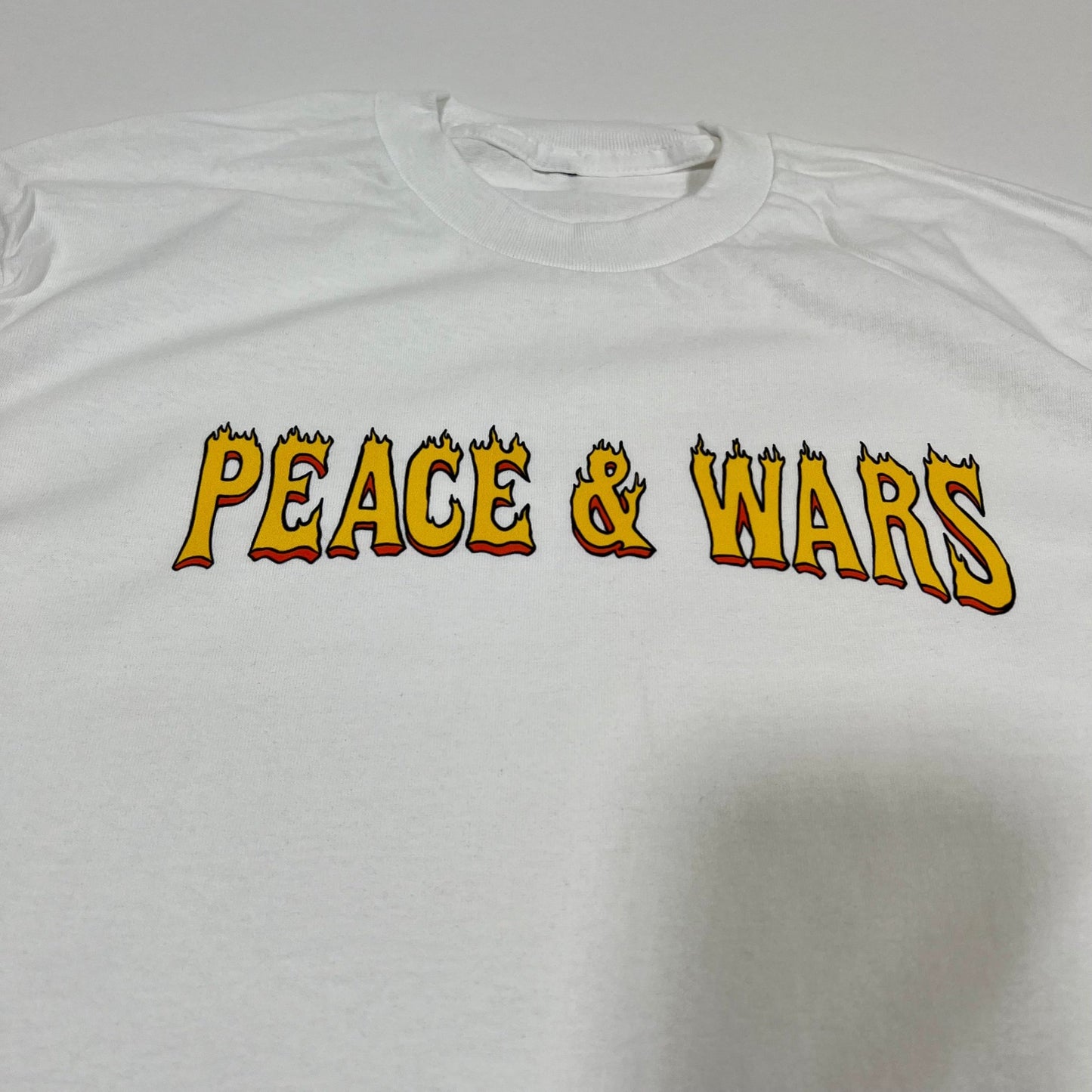 "Peace & Wars OG Logo T-Shirt featuring iconic design, made from 100% combed ringspun cotton, unisex fit, perfect for sci-fi and alien invasion fans."